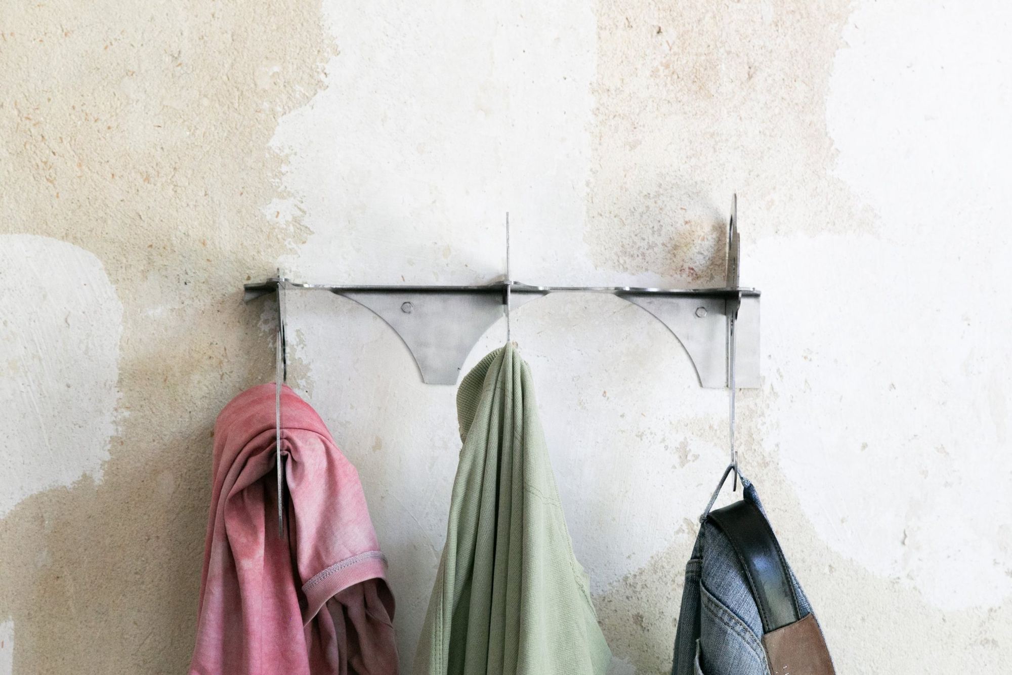 Wandgarderobe aus Metallresten mit Kleidung