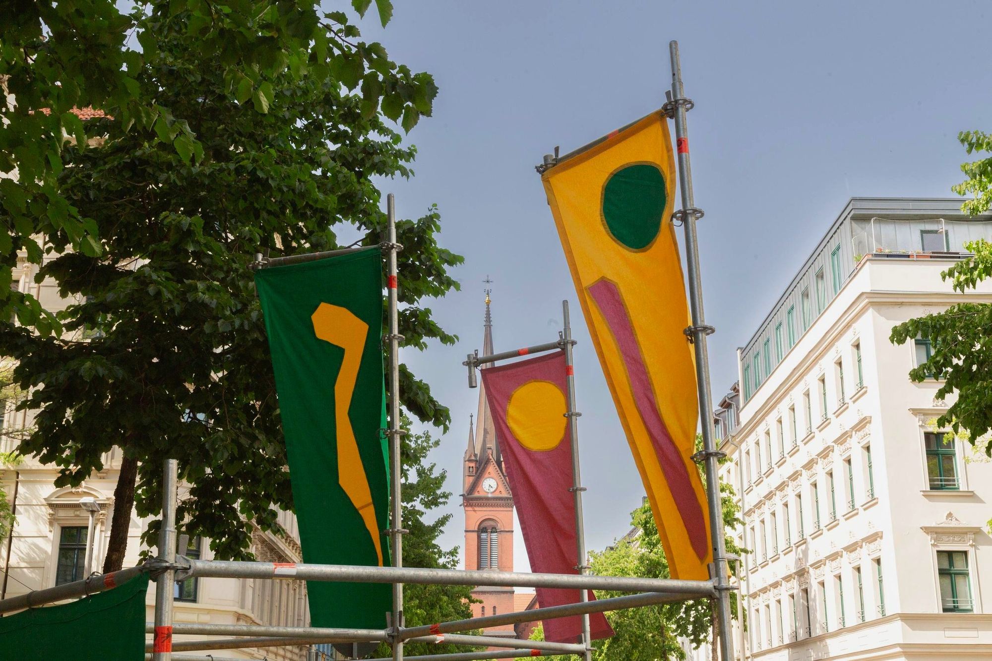 Farbige Fahnen vor einem Kirchturm