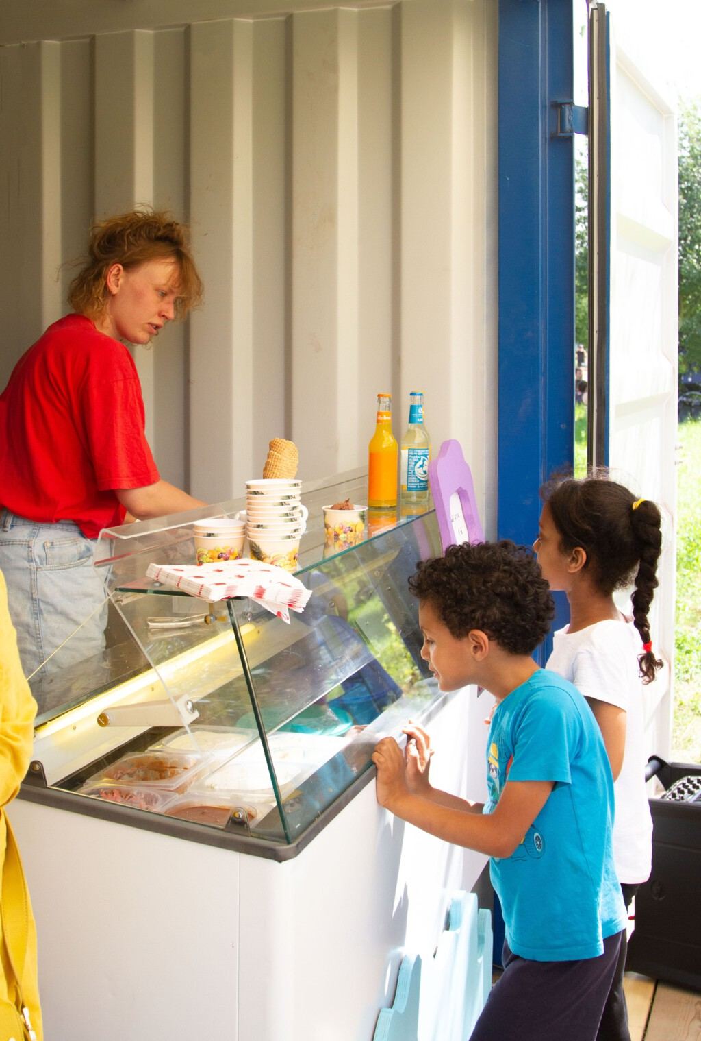 Kinder schauen in die Eistheke im Container